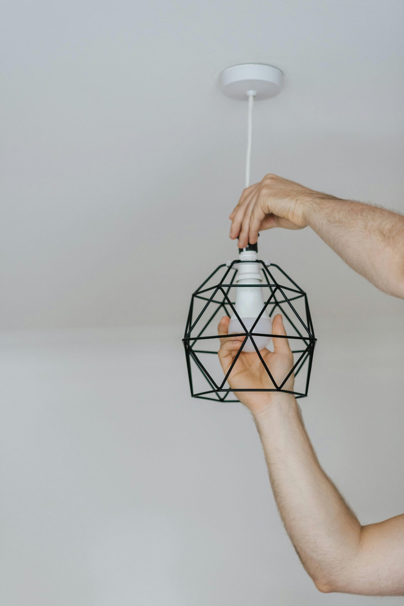 Handyman installing a modern light fixture in Marco Island.