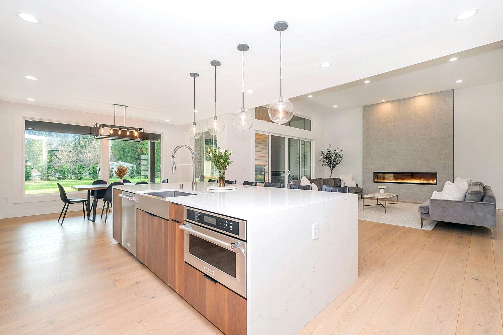 Modern Kitchen with a white countertop, wood floors, and modern lights in Old Naples.
