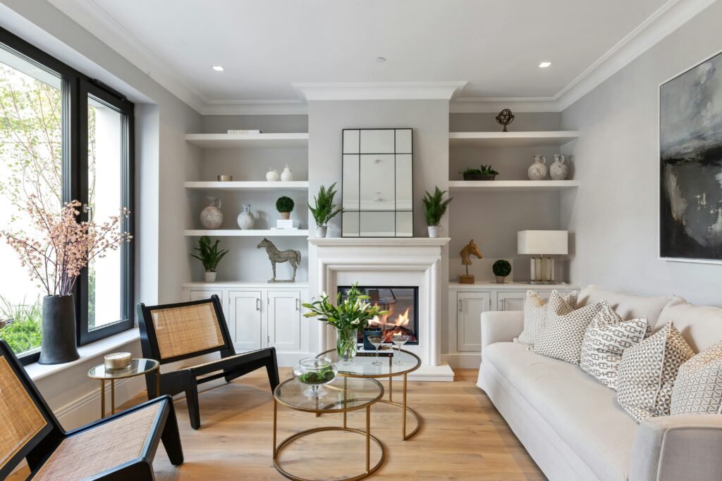 Modern living room with LVP flooring, grey walls, a white mantel, built-in shelves, and a fireplace in Bonita Springs.