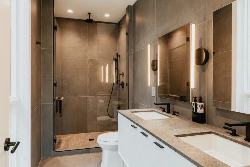 A brand new, fully remodeled bathroom with beautiful tile, lights, and cabinets in Marco Island, FL.
