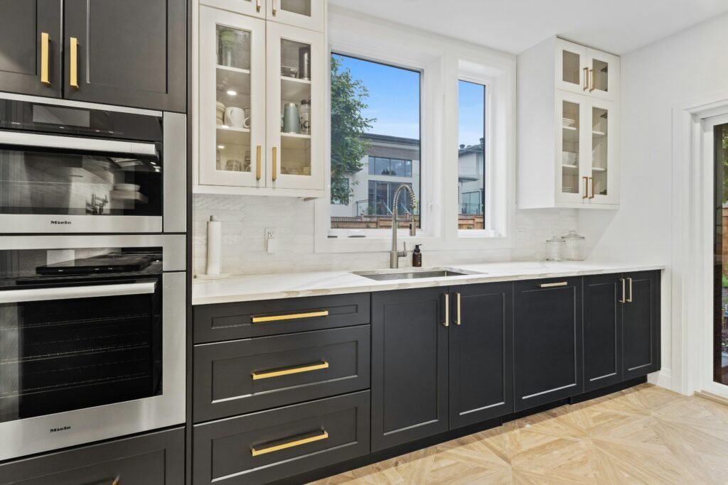 Modern kitchen with dark cabinets, white countertops, and large windows in Marco Island.
