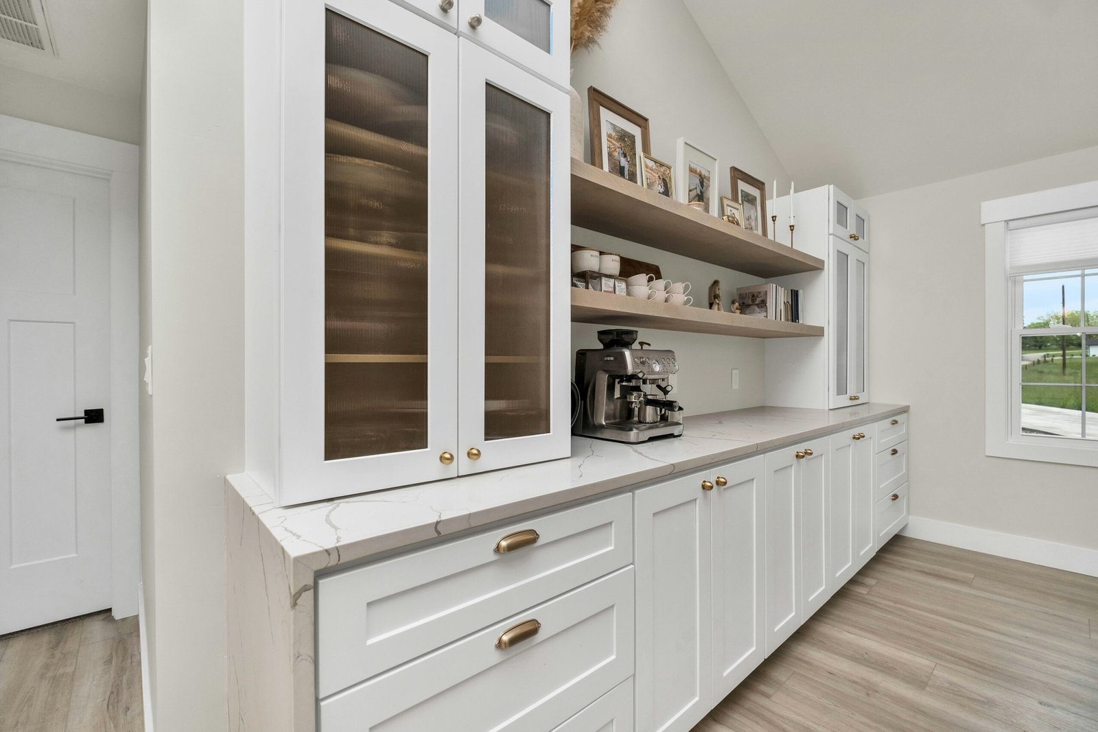 White cabinets, marble counter tops, and wood floors in a kitchen in Naples.