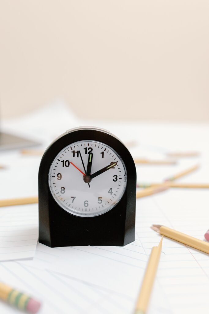 Black desk clock beside yellow pencils and sheets of paper in North Naples.