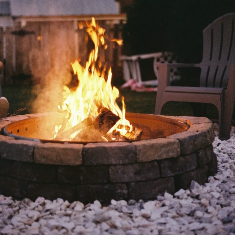 Custom fire pit built with bricks and white rocks around the pit in Bonita Springs, FL.
