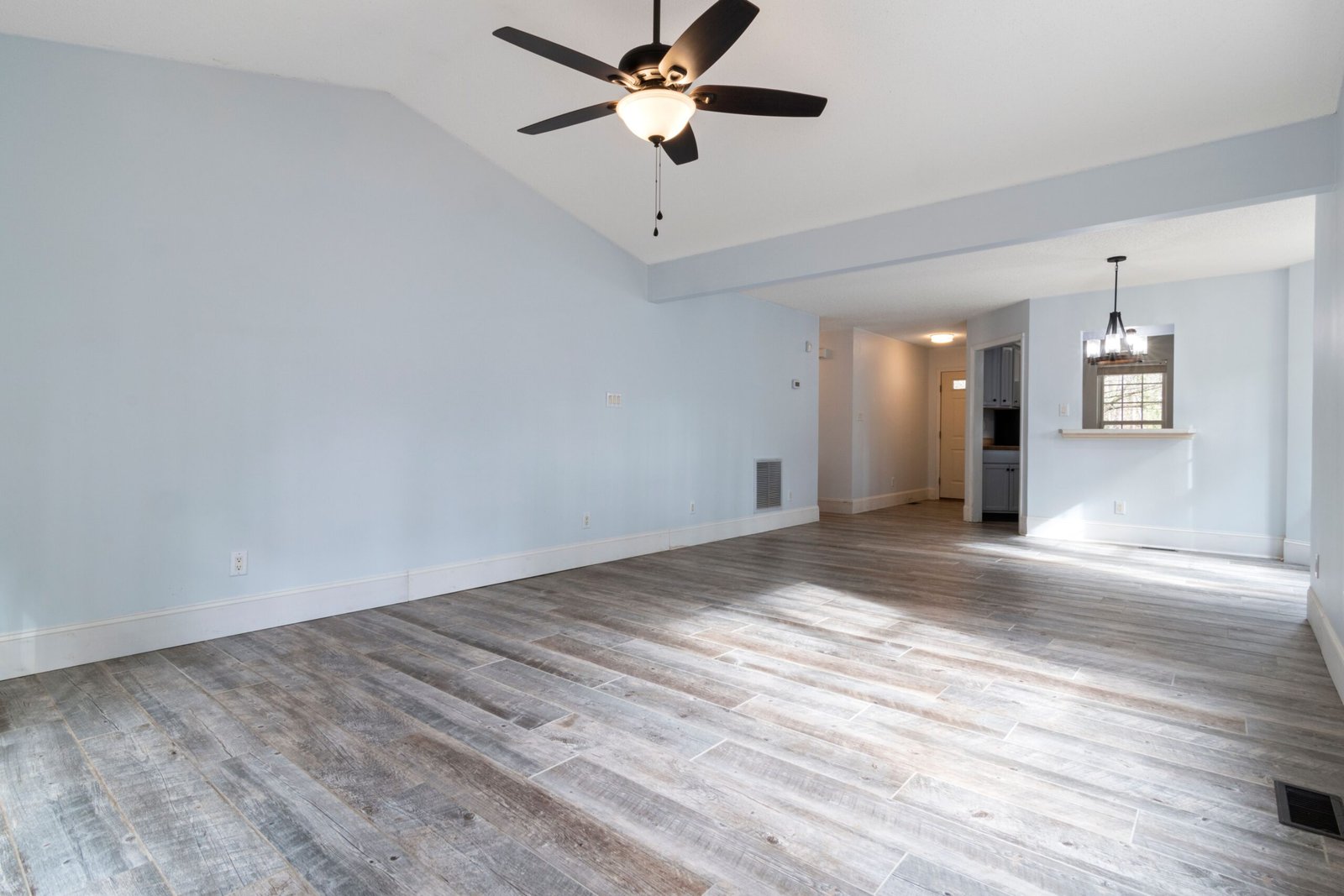 New, grey LVP flooring in a room with white walls in Naples.