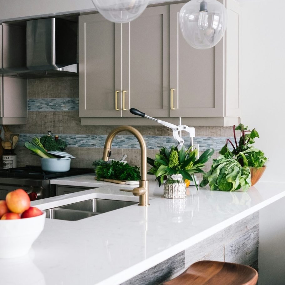 Modern kitchen with a white countertop, new tile backsplash, and stylish light fixtures in Bonita Springs, FL.