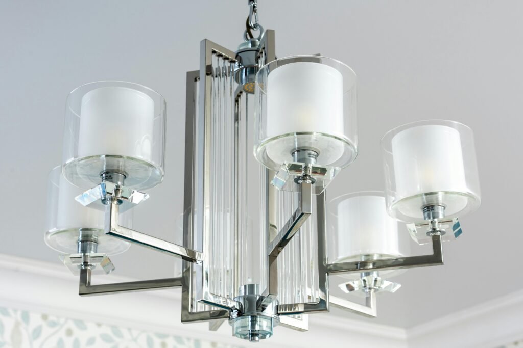 Modern chandelier with glass shades and metallic accents. Bright and elegant design.
