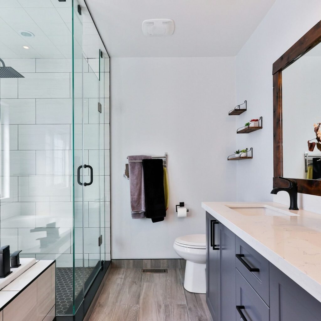 Modern bathroom with glass shower, dark wood accents, and sleek vanity in Marco Island, FL. 