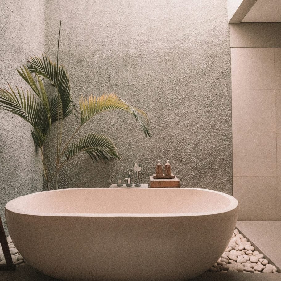 A modern, round bathtub and custom tile in a textured bathroom setting in Marco Island, FL.