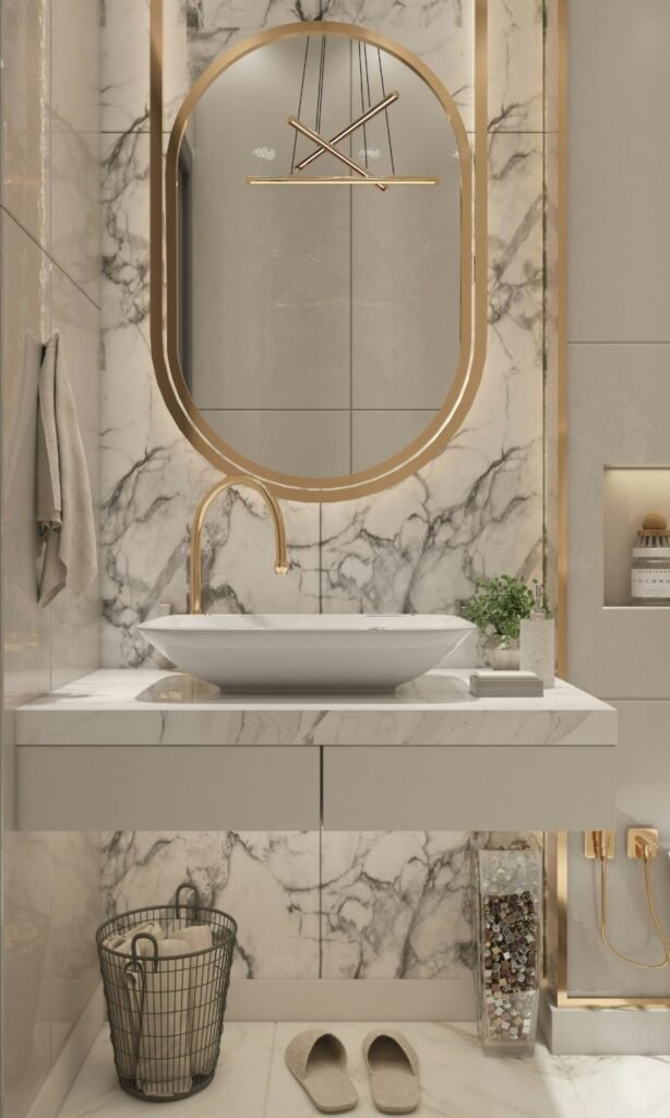 Custom modern bathroom featuring a marble wall, gold accents, a round mirror, and a stylish sink in Marco Island, FL.
