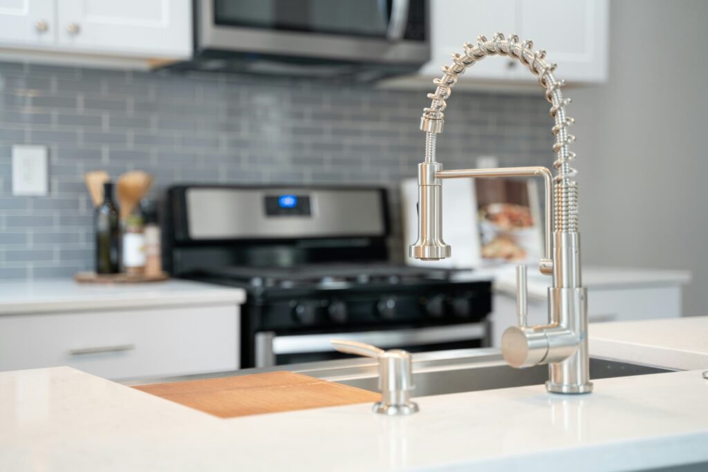 New, silver, kitchen sink faucet installed in Old Naples.