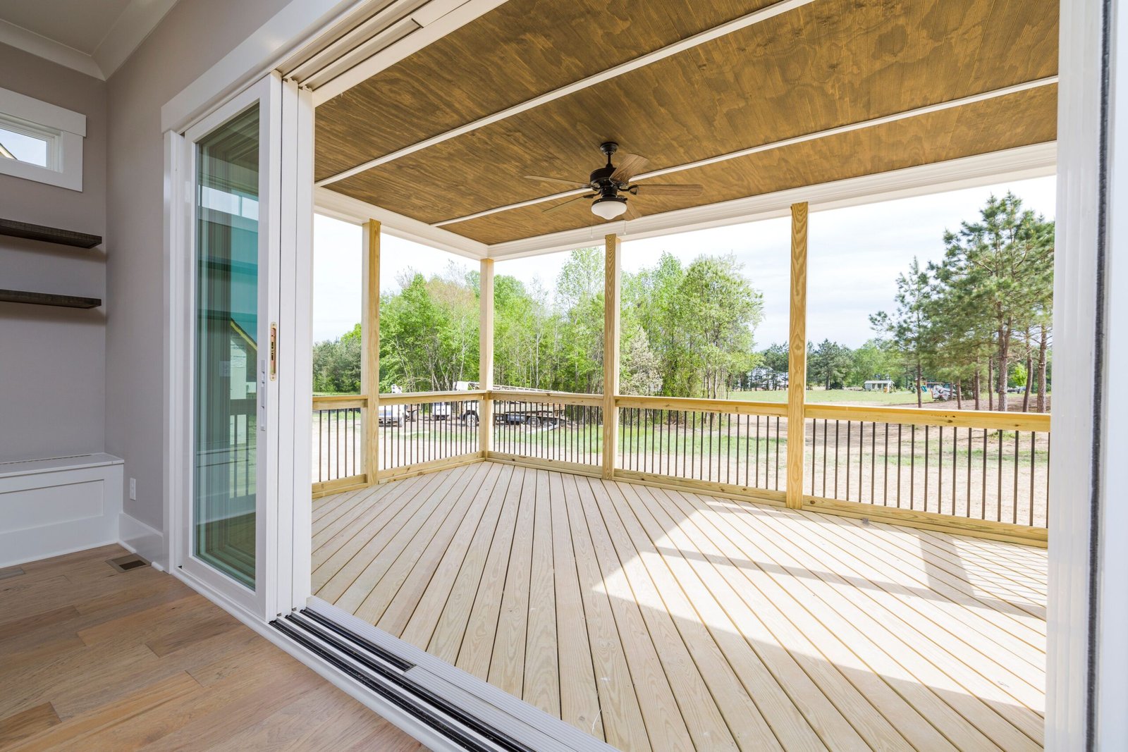 A large sliding glass door open to a wood deck in Naples.