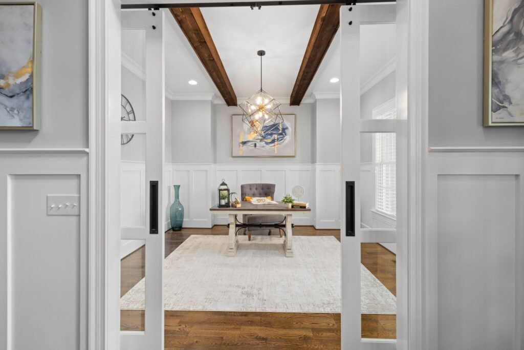 Bright, modern interior with beams, a chandelier, and a coffee table in a welcoming space.